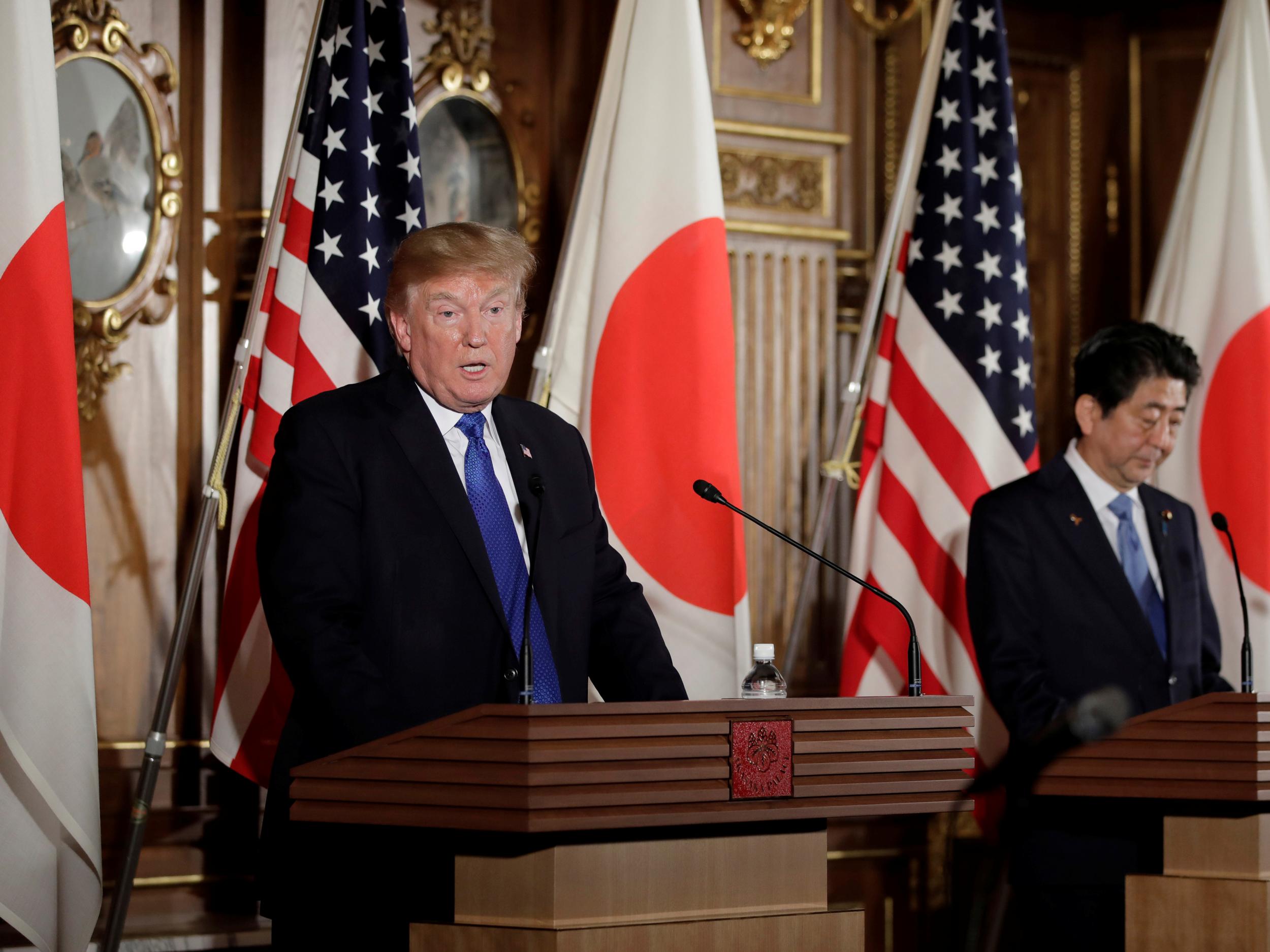 US President Donald Trump speaks as Shinzo Abe, Japan's Prime Minister, looks on during a news conference at Akasaka Palace in Tokyo