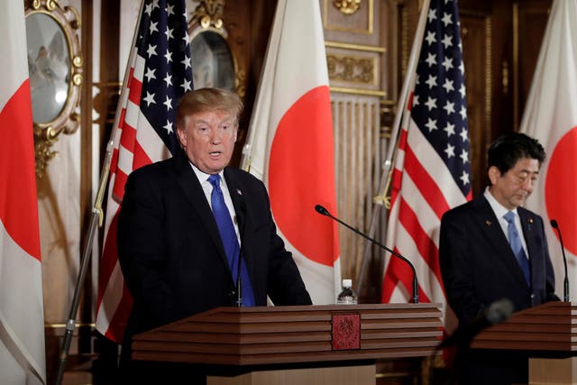 US President Donald Trump speaks as Shinzo Abe, Japan's Prime Minister, looks on during a news conference at Akasaka Palace in Tokyo