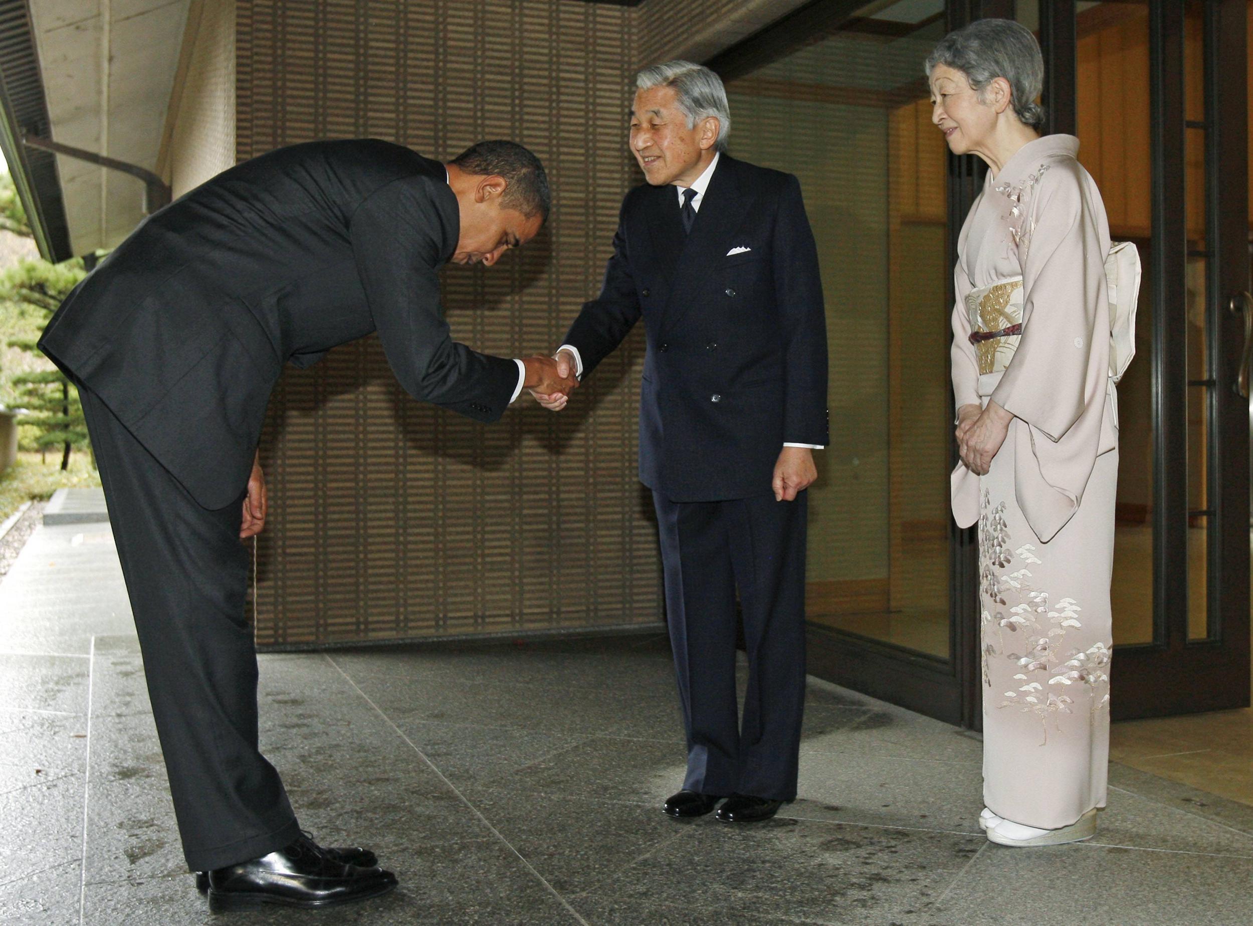 President Obama bends low as he is greeted by Emperor Akihito and his wife Michiko