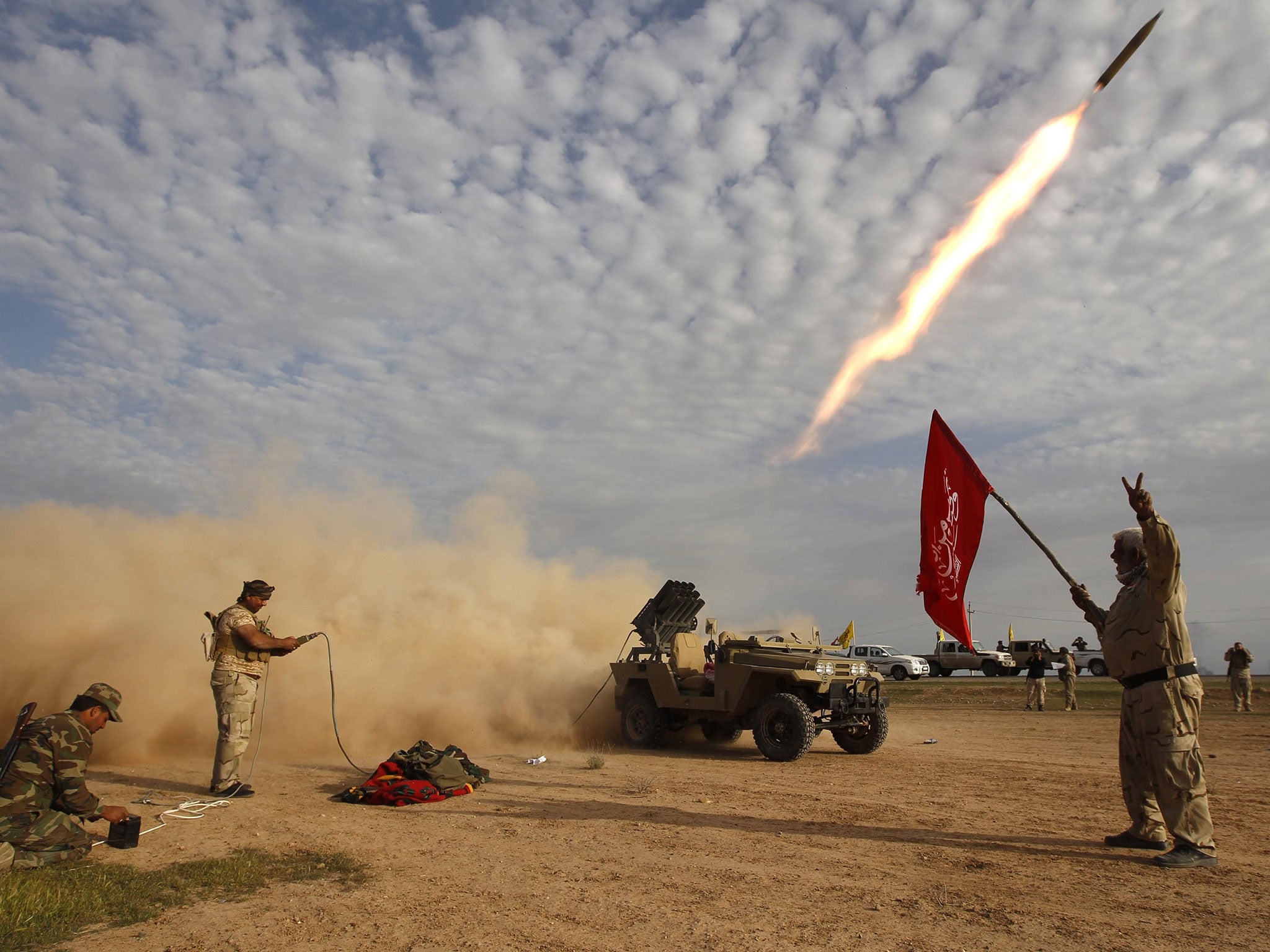 Iraqi forces fought back to take Tikrit and the surrounding desert in 2015. Here, Shia fighters are seen launching a rocket during clashes with Isis militants on the outskirts of the city