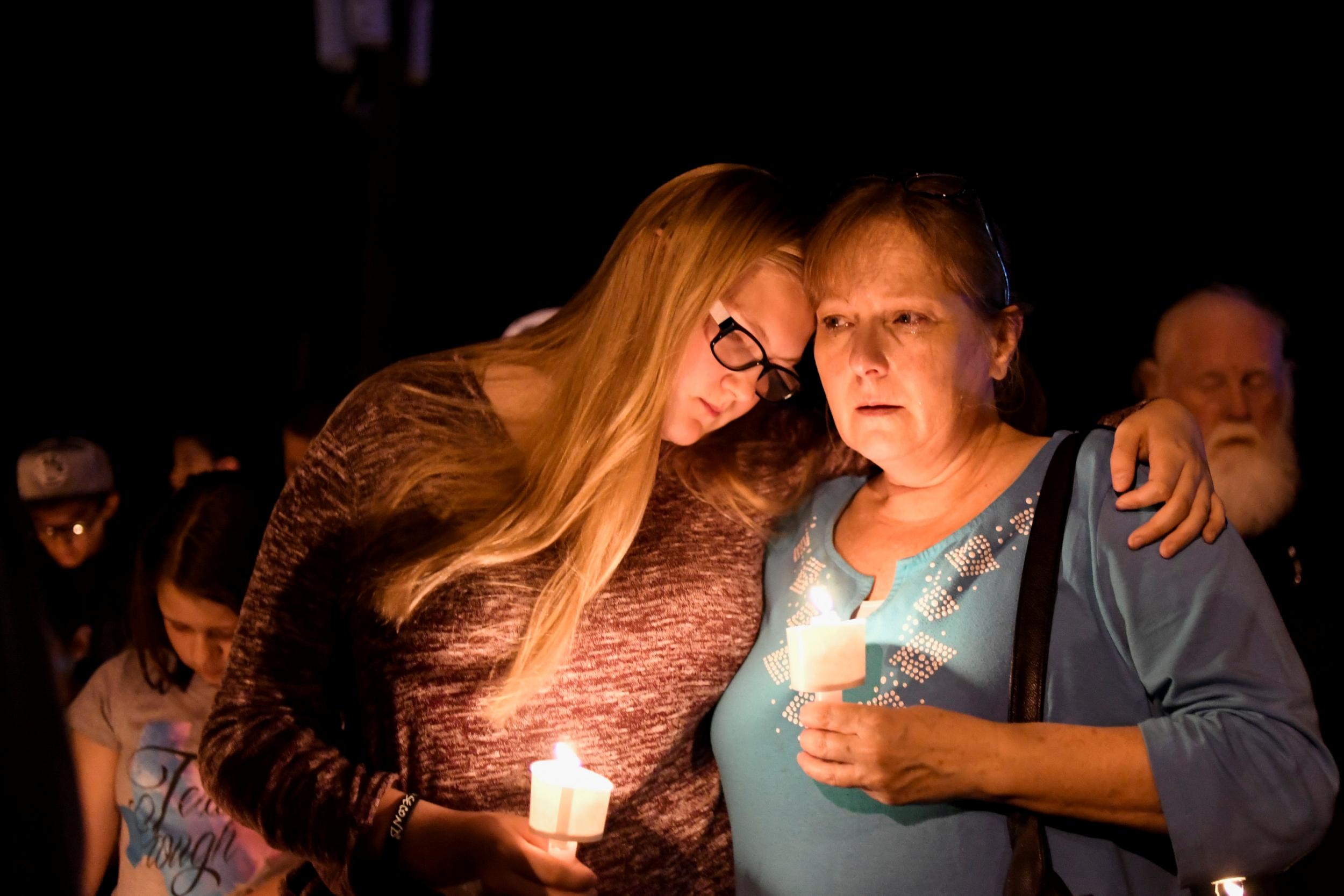 Residents embrace during a candlelight vigil for victims (Reuters)