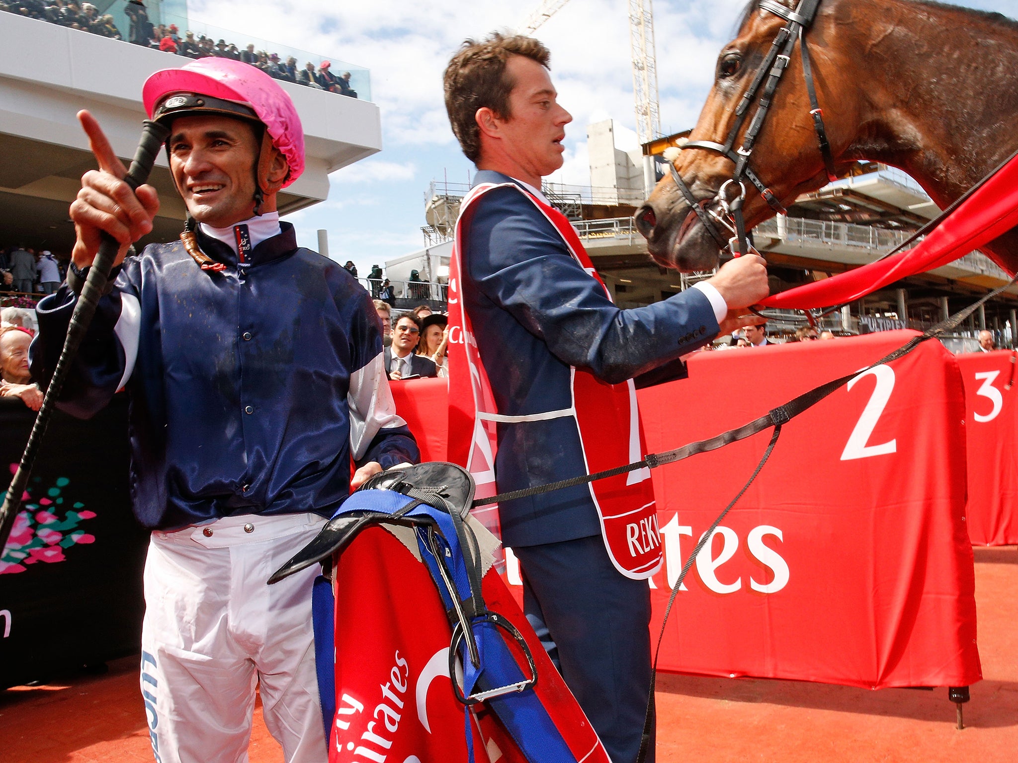 Corey Brown celebrates after dismounting off Melbourne Cup winner Rekindling