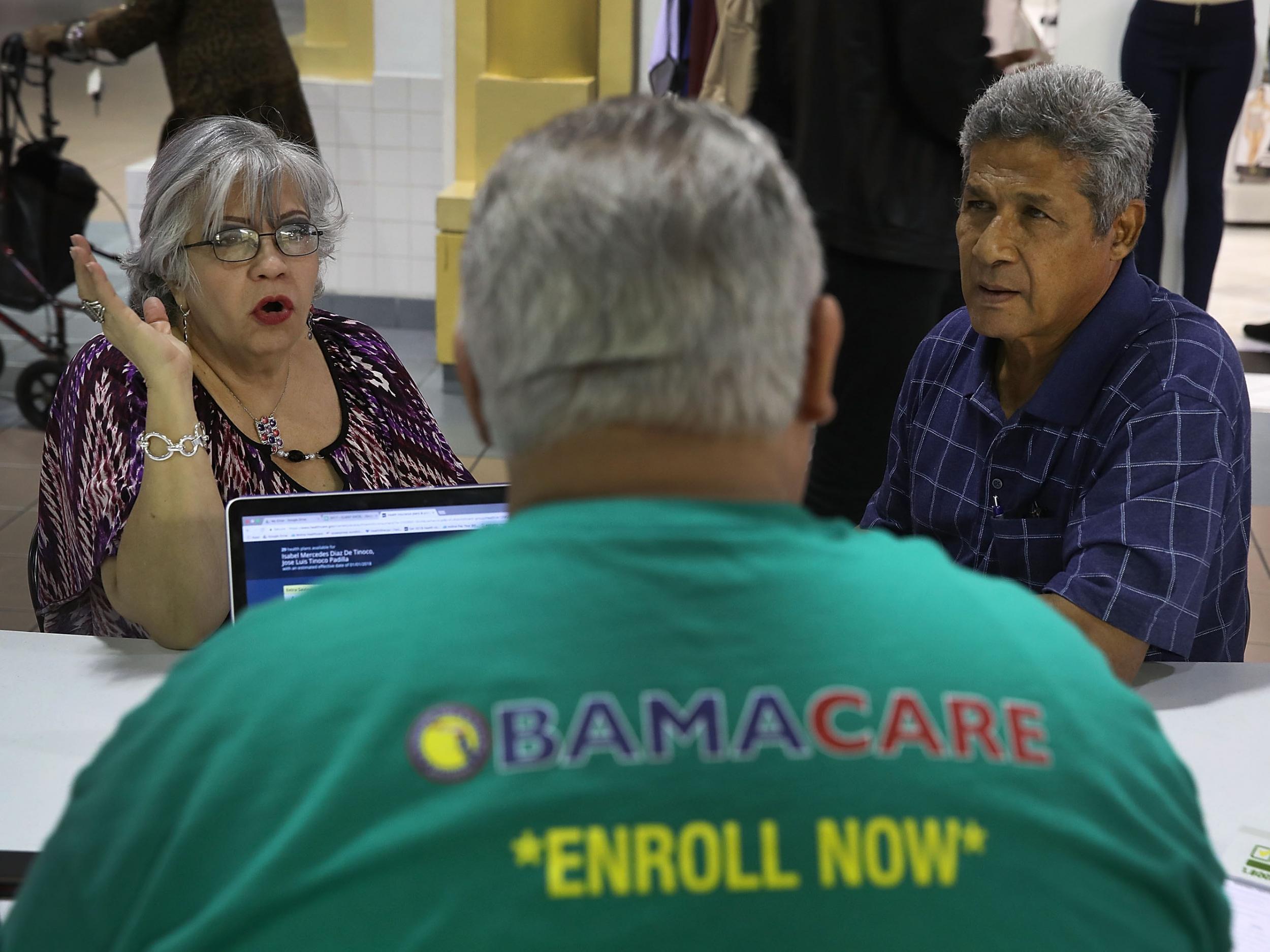 Isabel Diaz Tinoco and Jose Luis Tinoco speak with an insurance agent as they shop for insurance under the Affordable Care Act in Miami, Florida.