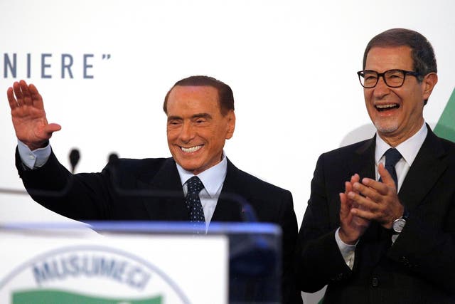 Forza Italia party leader Silvio Berlusconi waves to supporters next to local candidate Nello Musumeci during a rally in Catania