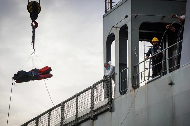 Rescuers recover a dead body from the Spanish ship 'Cantabria' in the harbour of Salerno, Italy