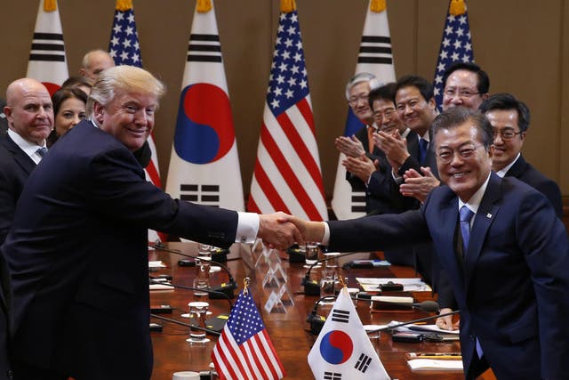 Trump and South Korean President Moon Jae-in shake hands before their summit meeting in Seoul