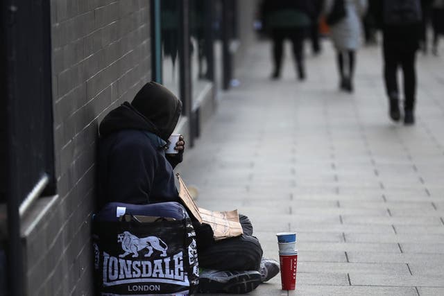 A homeless man begs for small change on the streets of Manchester