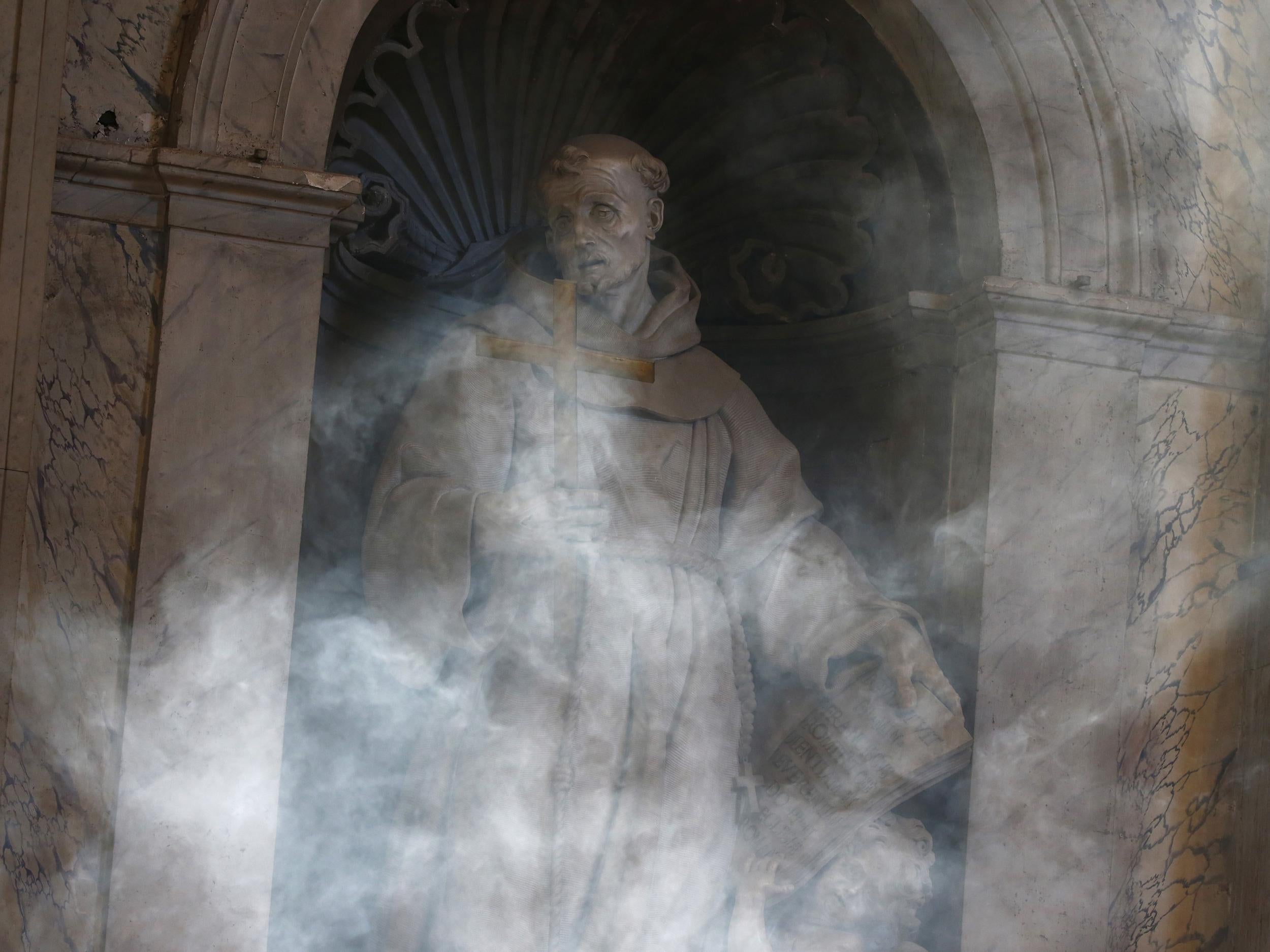 A statue is shrouded in smoke at Saint Peter's Basilica