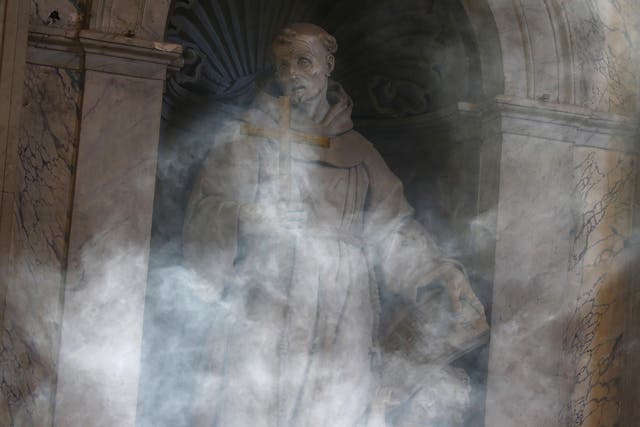 A statue is shrouded in smoke at Saint Peter's Basilica