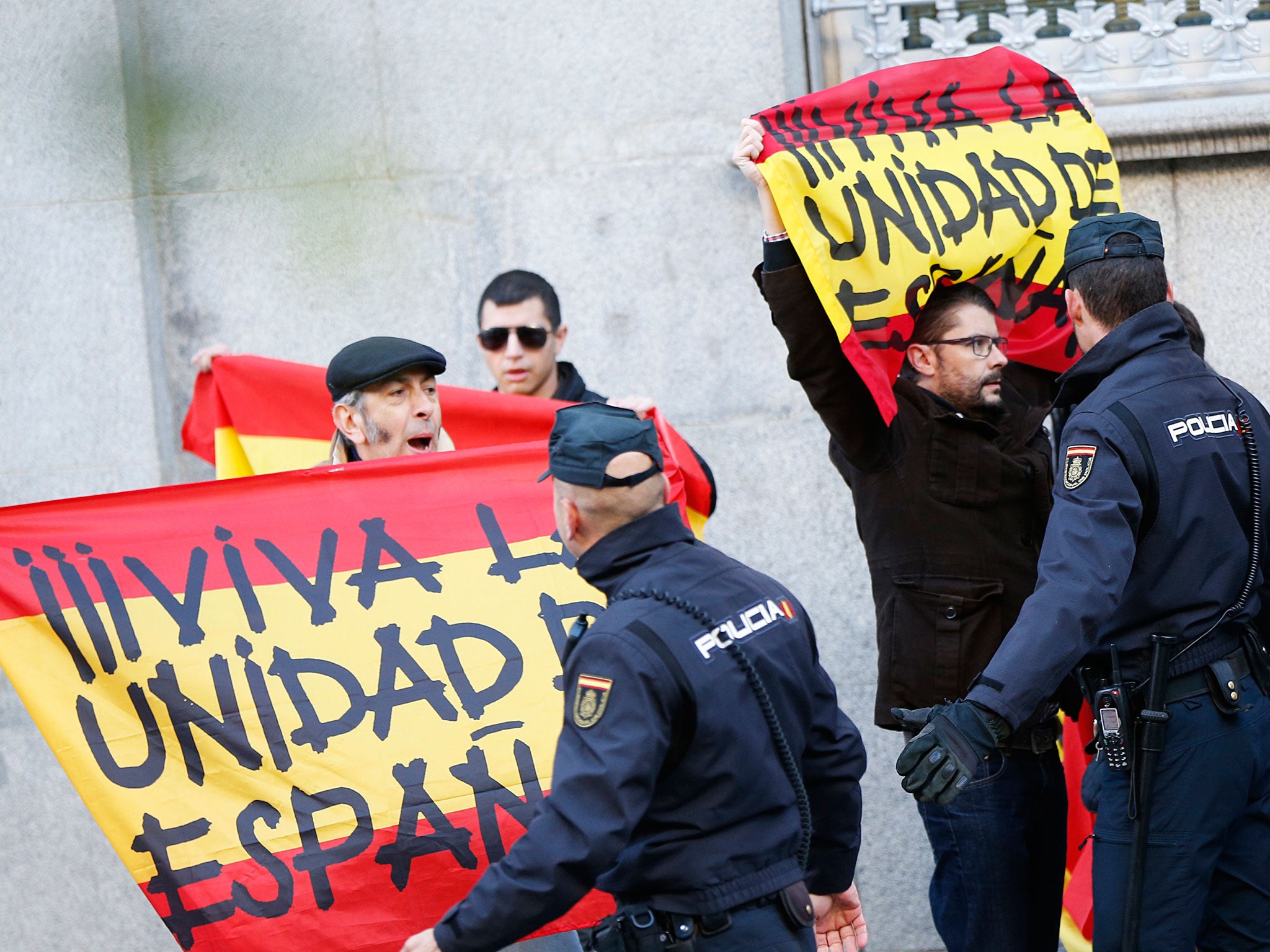 Right-wind protesters holding Spanish flags reading 'Long live a united Spain' outside the Supreme Court in Madrid