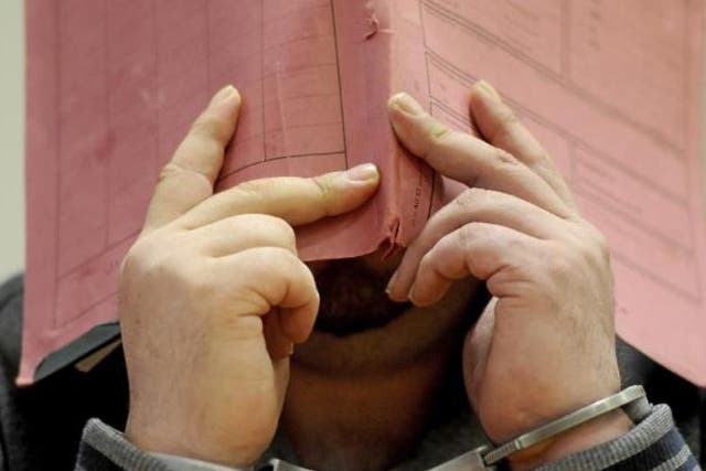 Former nurse Niels Hoegel conceals his face attending district court in Oldenburg, Germany