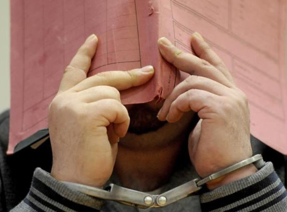 Former nurse Niels Hoegel conceals his face attending district court in Oldenburg, Germany