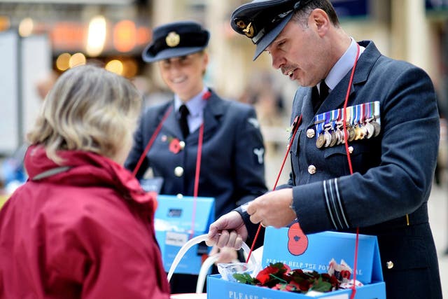 Members of the armed forces sell poppies at London’s Charing Cross station