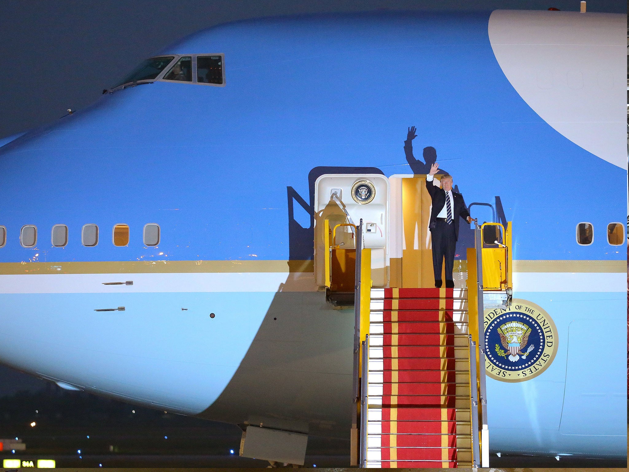 Donald Trump waves from the door of Air Force One plane as he arrives at Noi Bai International Airpot in Hanoi, Vietnam