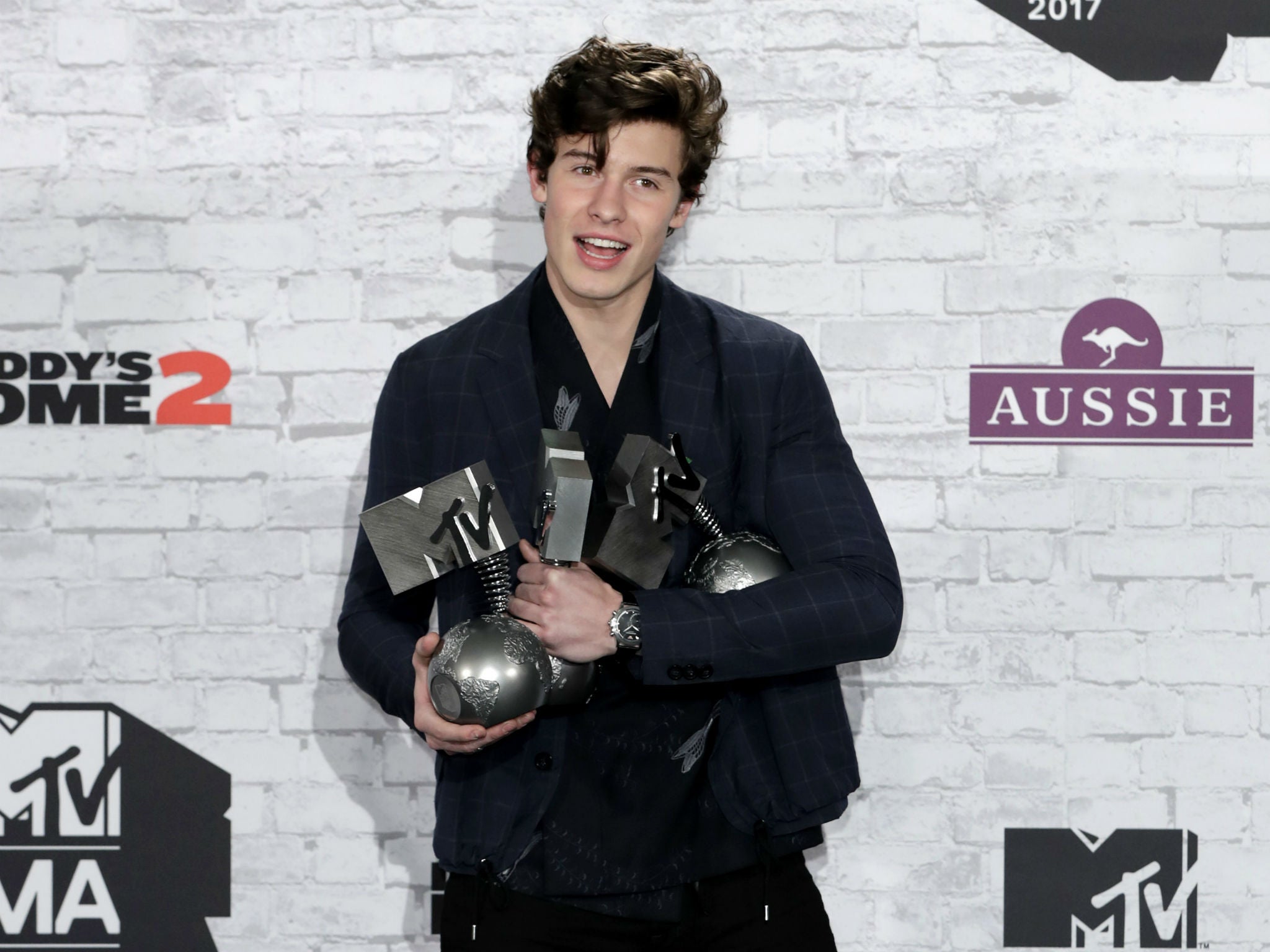 Shawn Mendes poses in the winner's room with awards for Biggest Fans, Best Artist and Best Song