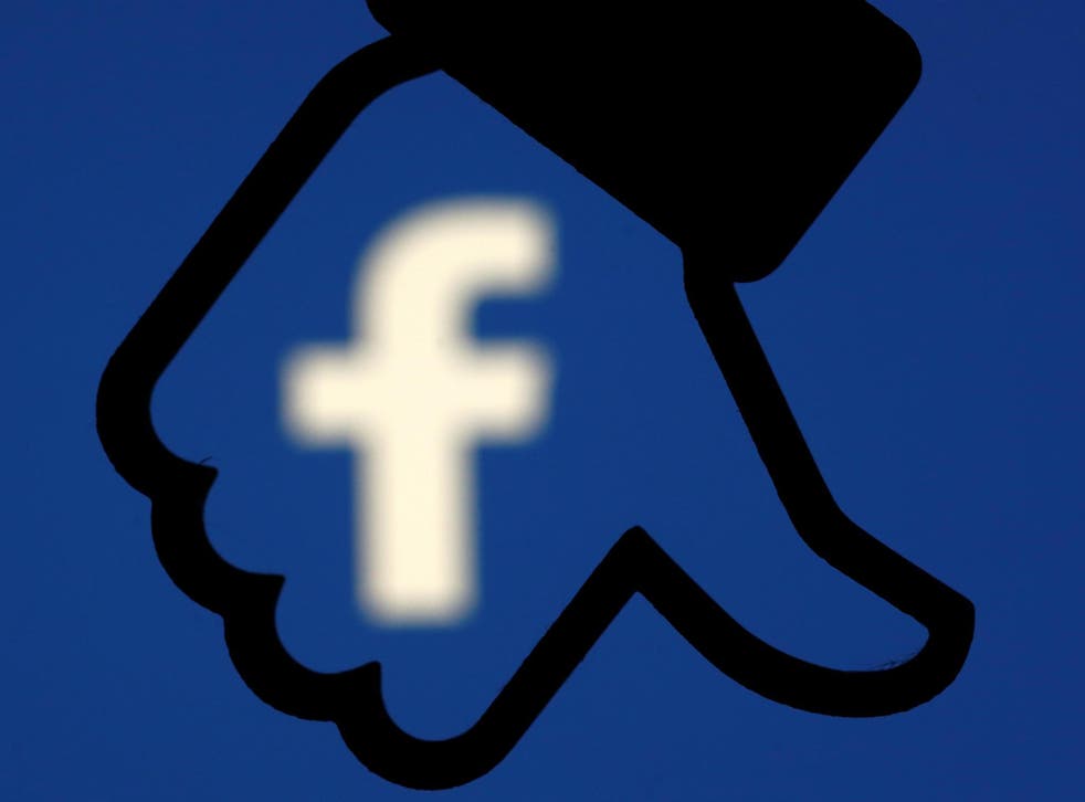 A 3D-printed Facebook dislike button is seen in front the Facebook logo, in this illustration taken October 25, 2017