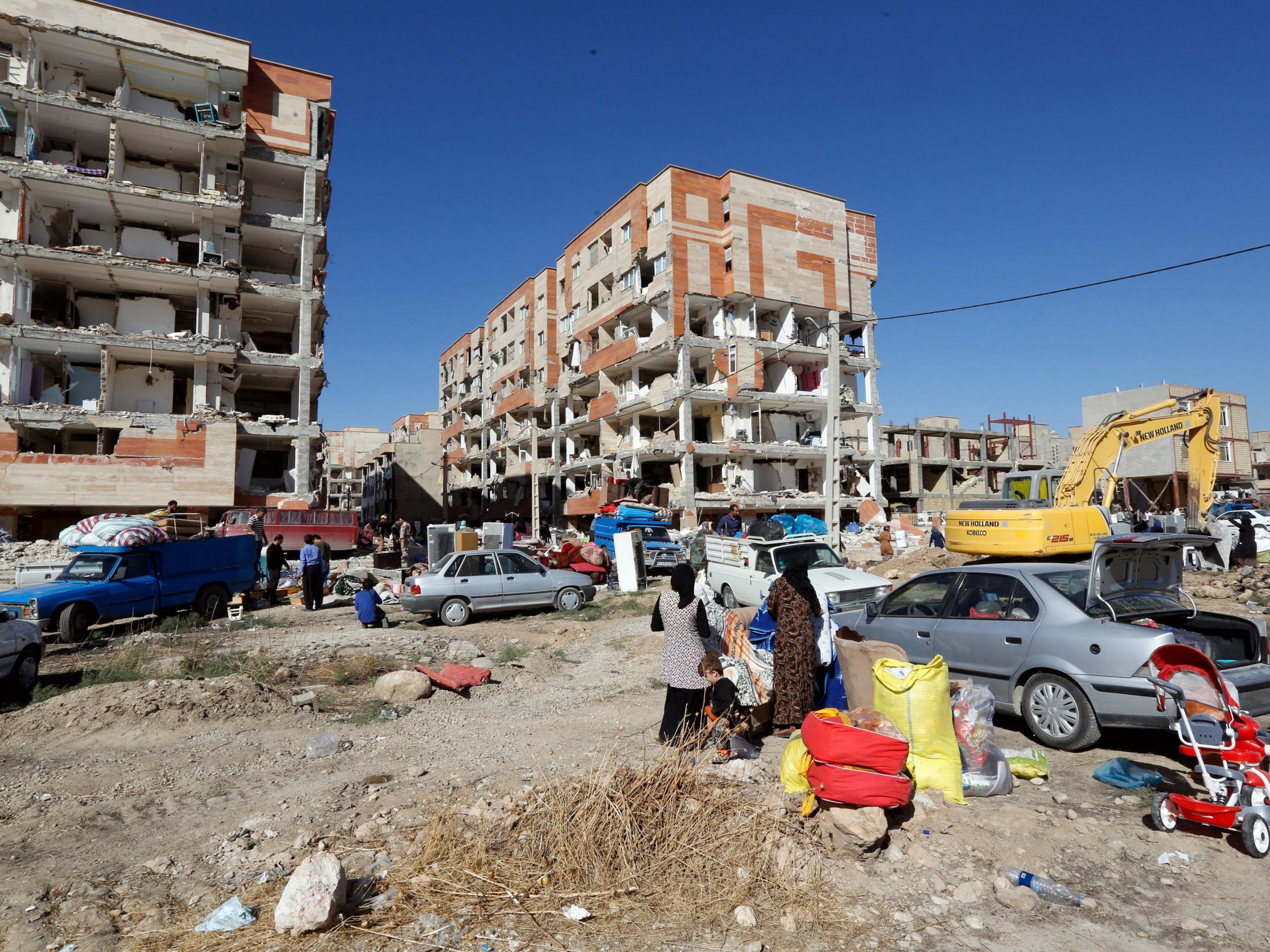 People collect belongings from damaged buildings in the city of Sarpol-e-Zahab in Kermanshah province