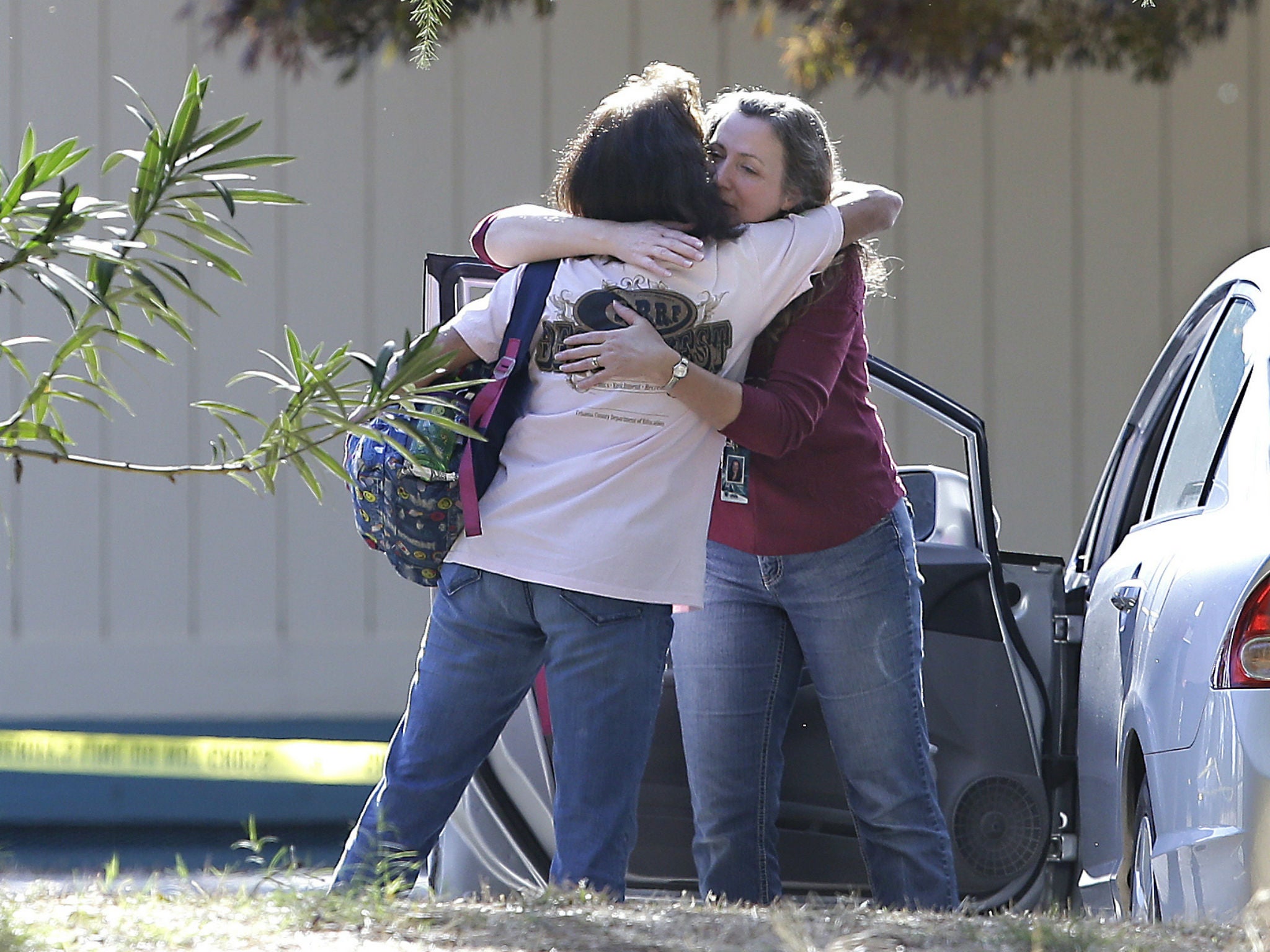 Two women embrace outside Rancho Tehama Elementary School, where a gunman opened fire Tuesday, Nov. 14, 2017, in Corning, California