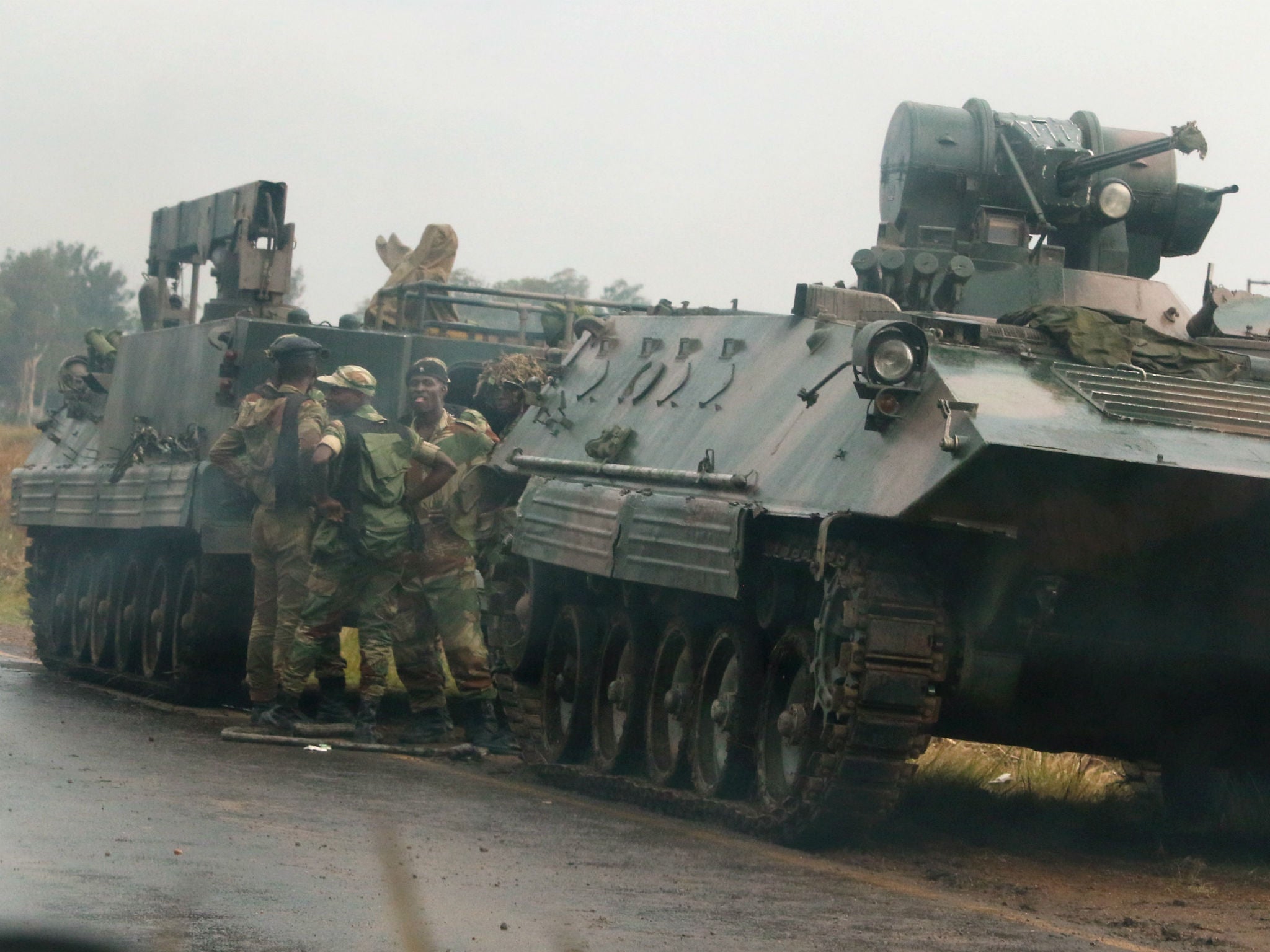 Soldiers stand beside military vehicles just outside Harare, Zimbabwe on November 14, 2017