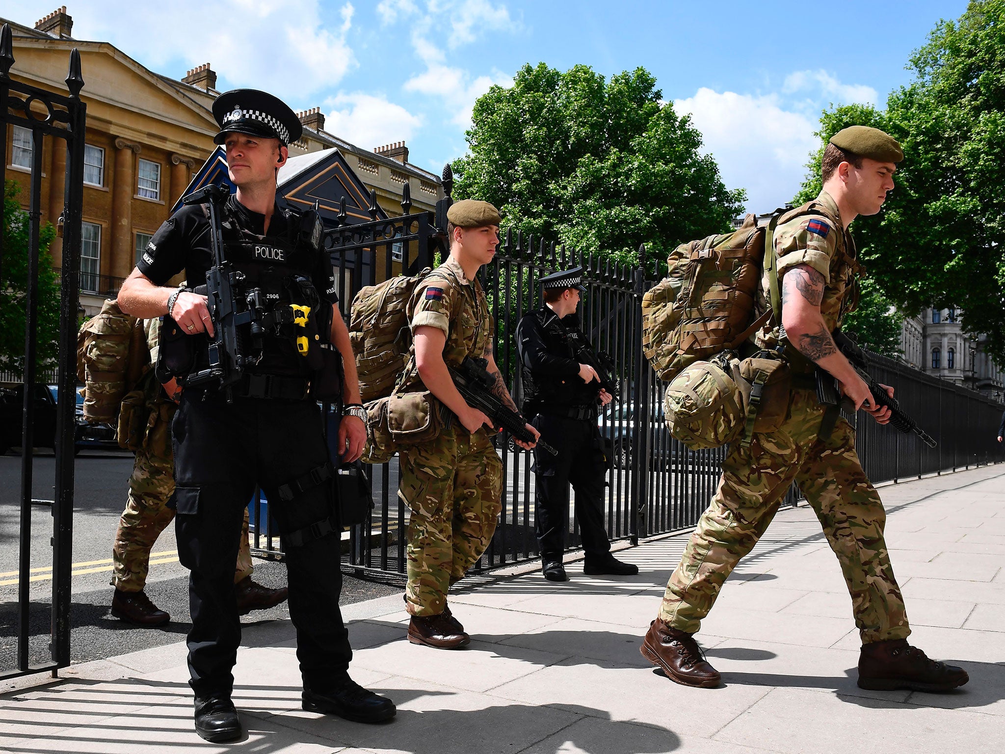 Ministry of Defence Police officers on guard as soldiers enter a building in central London on 24 May 2017