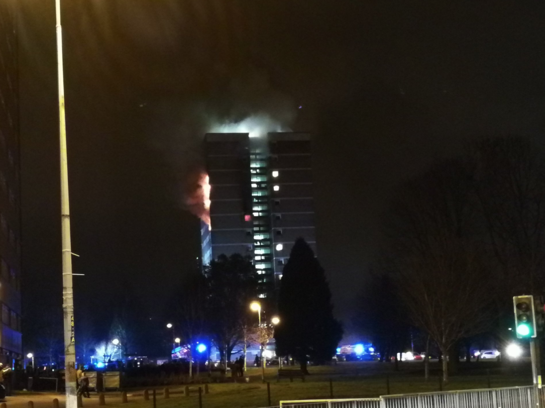 Flames pour from the side of Coolmoyne House in Dunmurry on the outskirts of Belfast