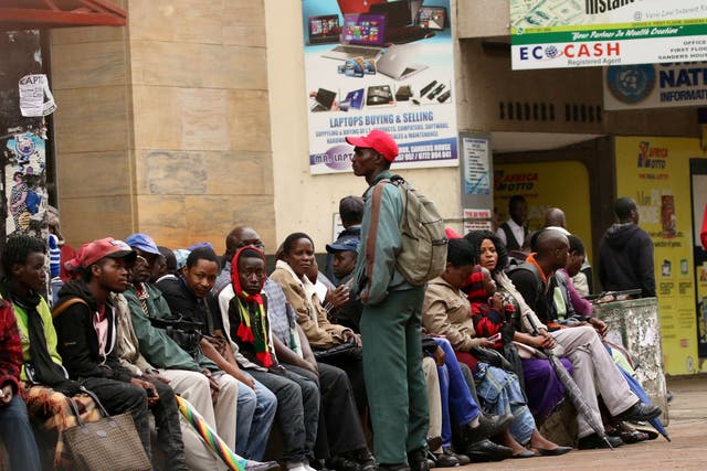People queue to draw money outside a bank in Harare, Zimbabwe