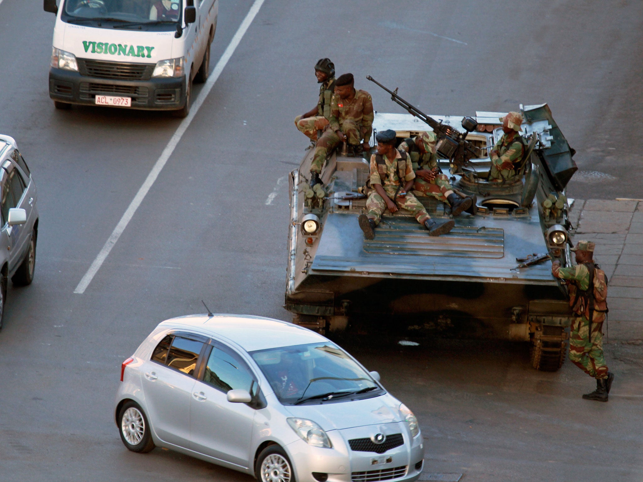 Soldiers man their position with a military vehicle outside the office of President Robert Mugabe in Harare