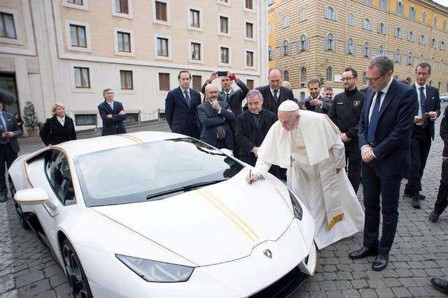 Pope Francis signs a Lamborghini Huracan prior to his Wednesday general audience in St Peter's square at the Vatican