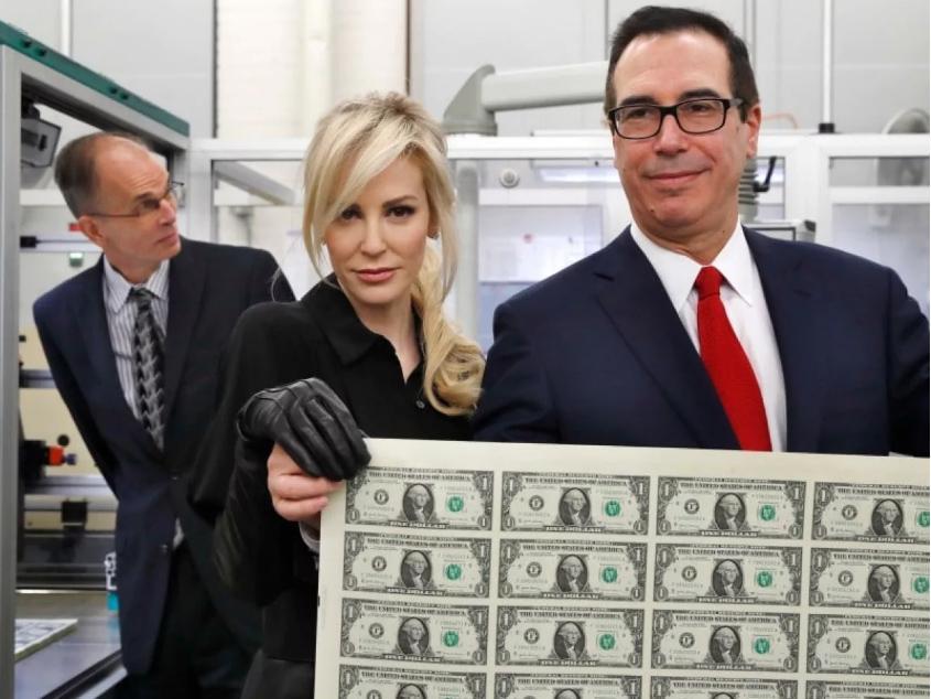 Treasury Secretary Steven Mnuchin and his wife, Louise Linton, hold up a sheet of new $1 bills, the first currency notes bearing his and US Treasurer Jovita Carranza's signatures