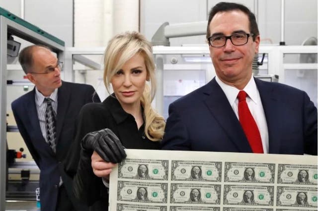 Treasury Secretary Steven Mnuchin and his wife, Louise Linton, hold up a sheet of new $1 bills, the first currency notes bearing his and US Treasurer Jovita Carranza's signatures