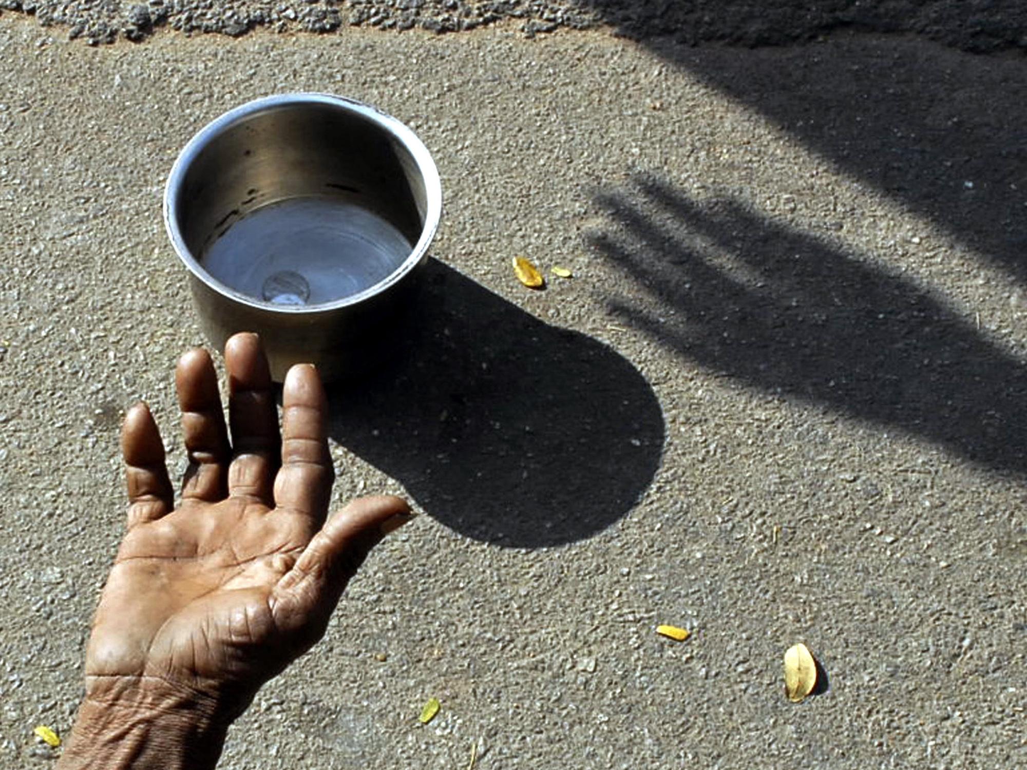A beggar extends his hand for money at a street in the southern Indian city of Hyderabad