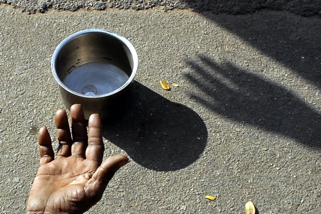 A beggar extends his hand for money at a street in the southern Indian city of Hyderabad