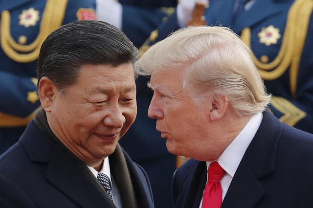 US President Donald Trump chats with Chinese President Xi Jinping during a welcome ceremony in Beijing on 9 November