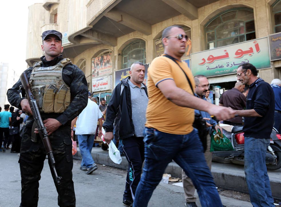 An Iraqi soldier guards a popular market in al-Gomhouria Street in central Baghdad