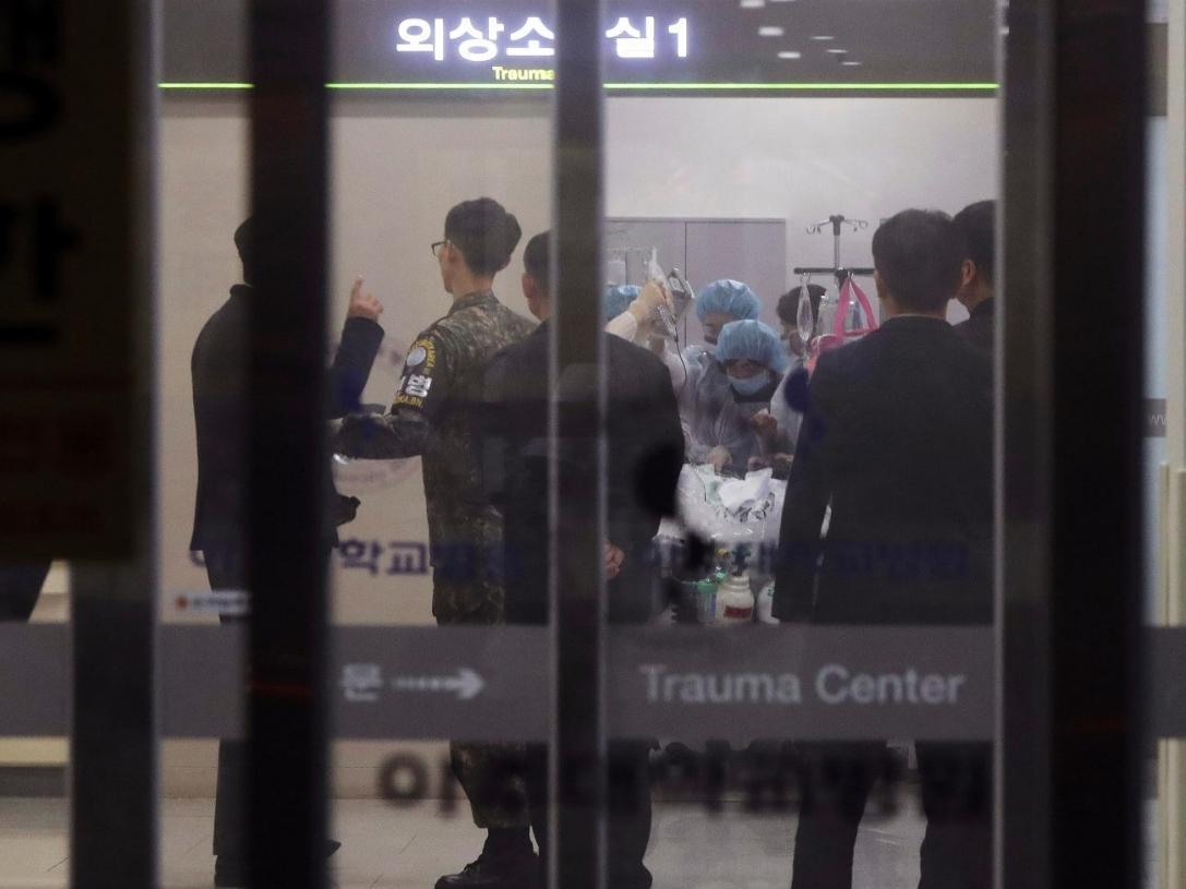 A South Korean soldier, second from left, is seen as medical personnel treat an injured person, believed to be a North Korean soldier, at a hospital in Suwon, South Korea