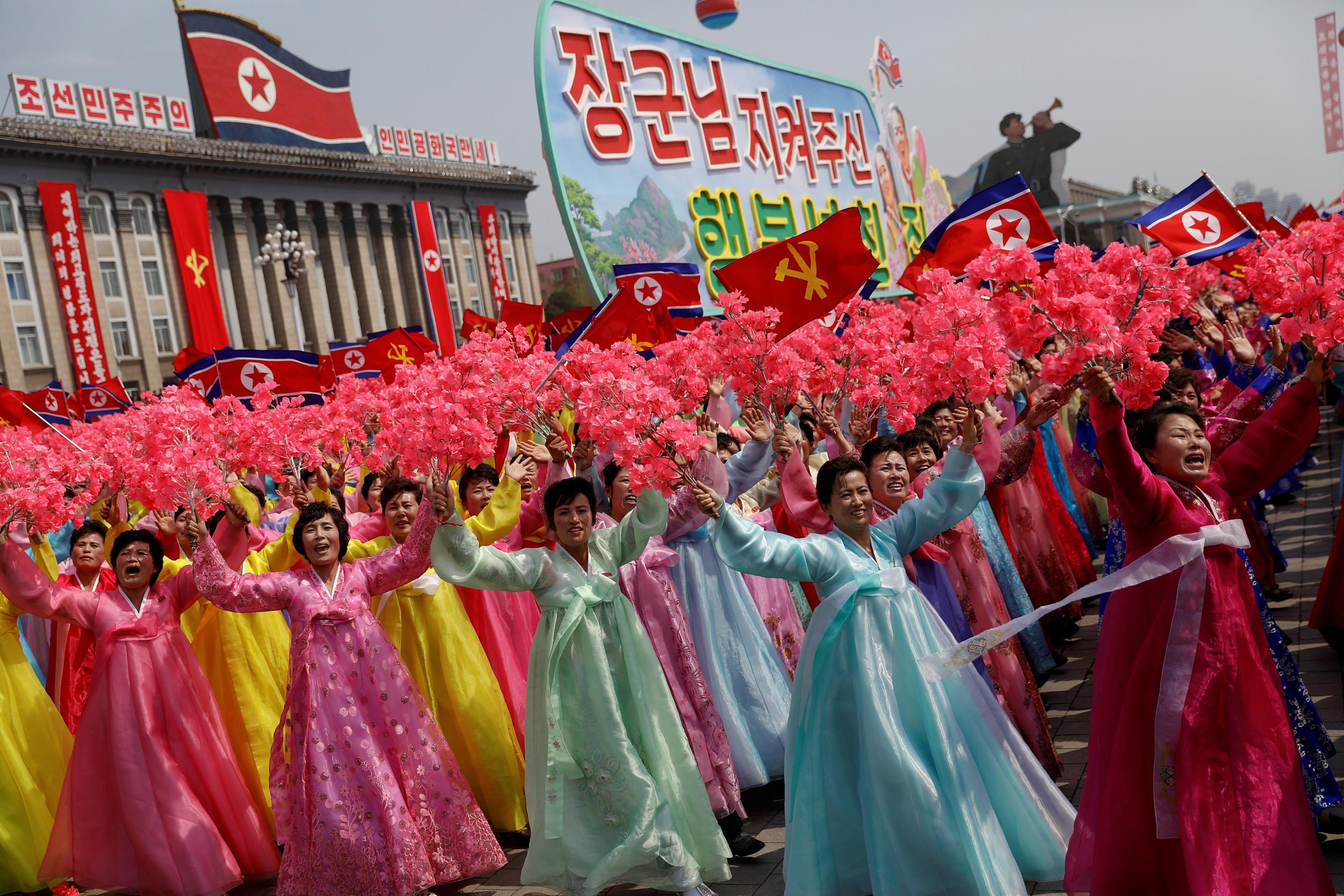 Women wearing traditional clothes react as they march past the stand with North Korean leader Kim Jong-un during a military parade marking the 105th birth anniversary of the country's founding father, Kim Il-sung in Pyongyang