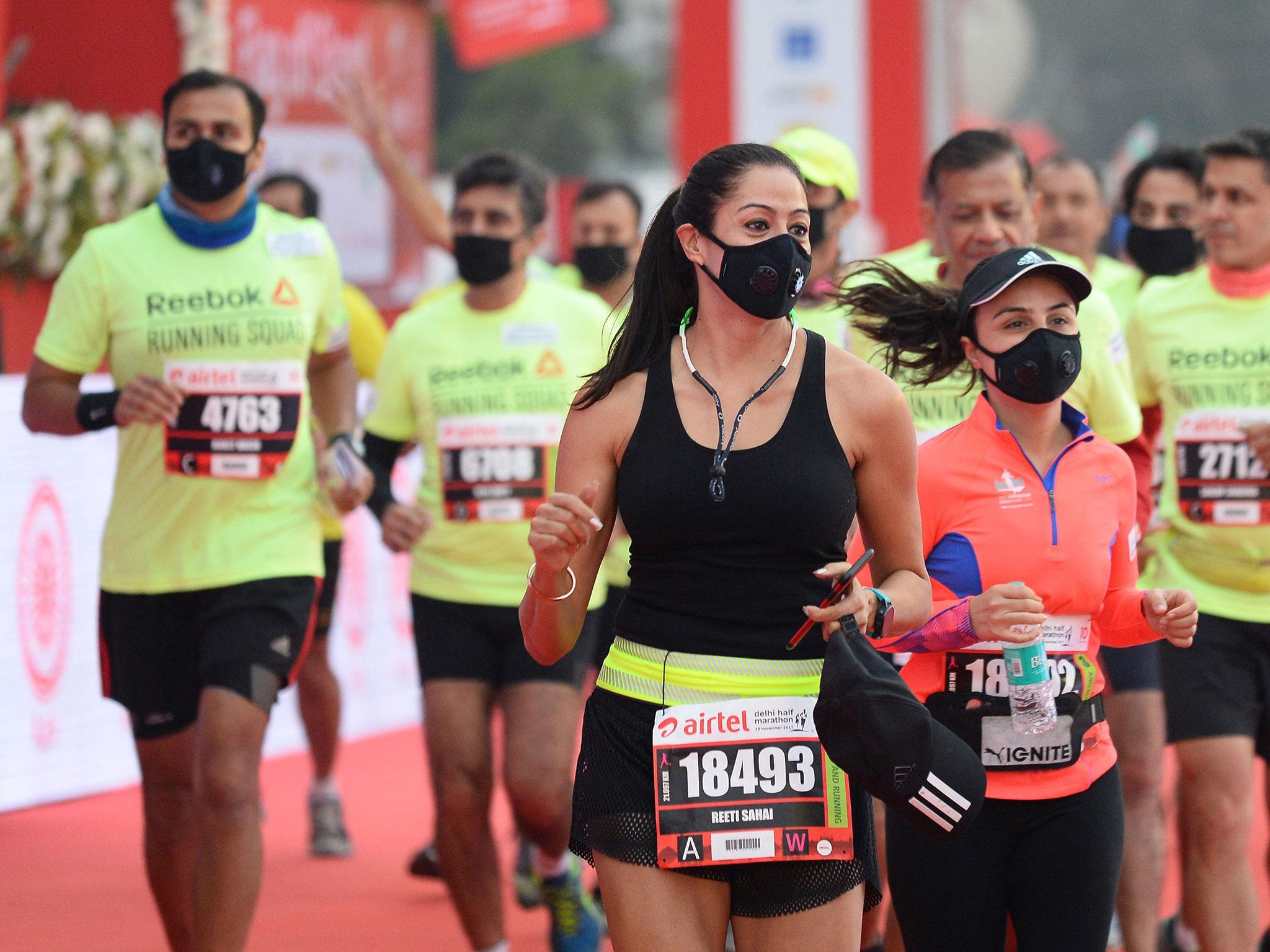 Men and women wear face mask as they take part in the Airtel Delhi Half Marathon 2017 in New Delhi