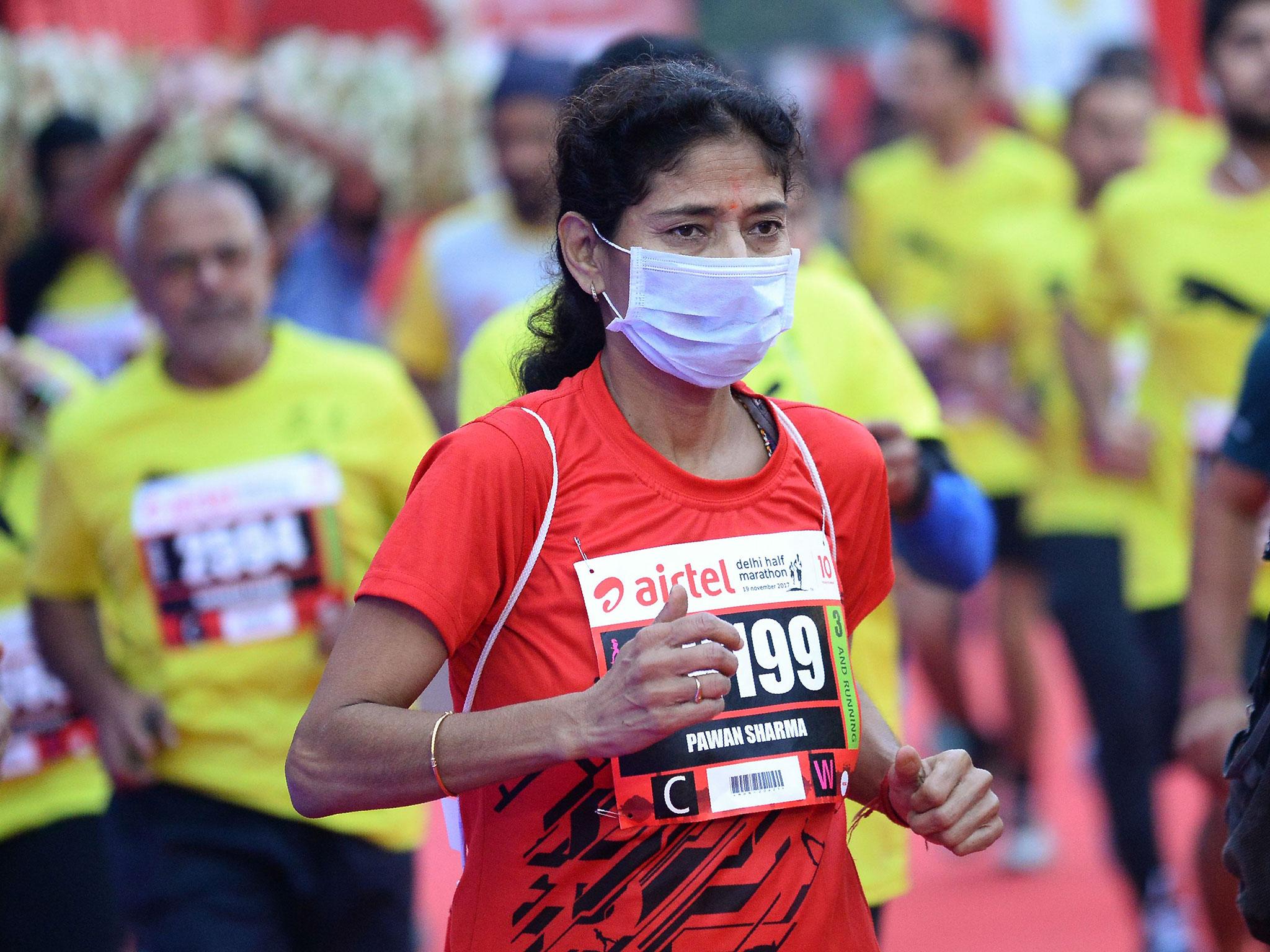 &#13;
A woman wears a face mask as she takes part in the Airtel Delhi Half Marathon 2017 &#13;