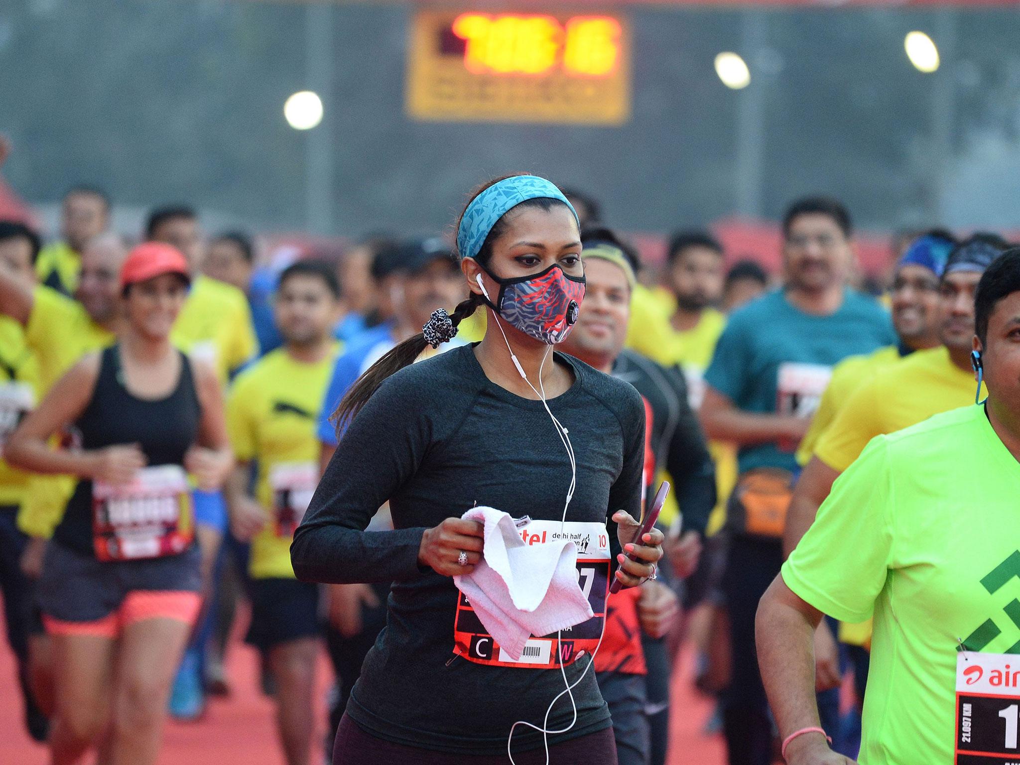 &#13;
A woman wears a face mask as runs through New Delhi &#13;