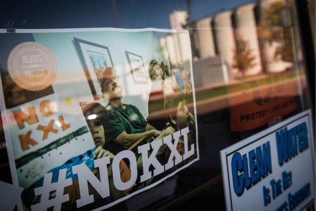 Signs against the proposed Keystone XL pipeline are taped to the window a hardware store on 11 October 2014 in Polk, Nebraska.