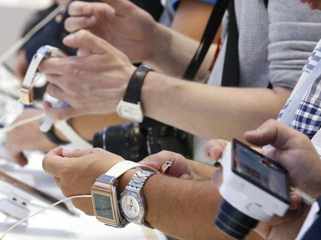 Journalists check out the Samsung Galaxy Gear smartwatch at the booth of Samsung during a media preview day at the IFA consumer electronics fair in Berlin, September 5, 2013