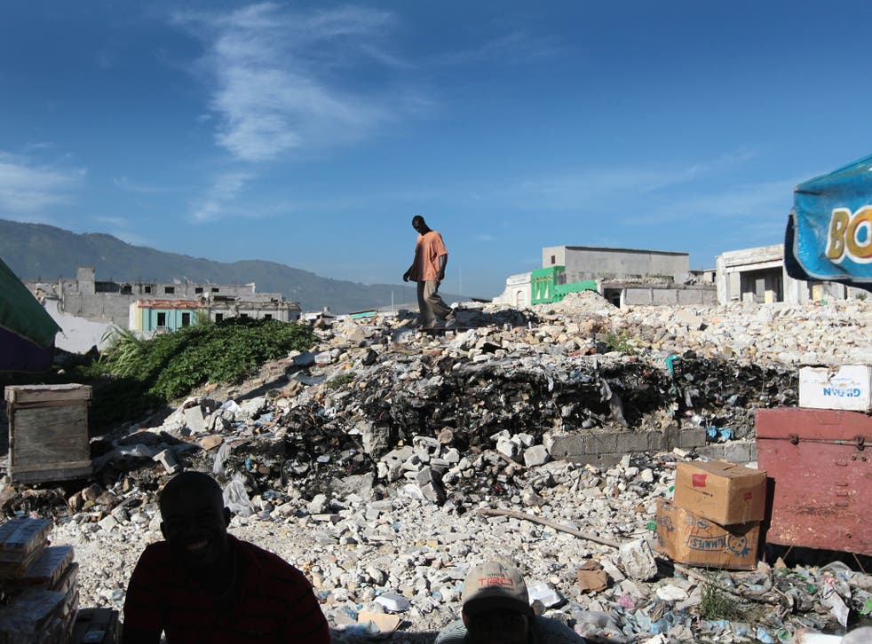 People examine a collapsed building after the 2010 earthquake. Advocates for Haitians say conditions in the island nation haven't improved nearly enough for Haitians to be deported.