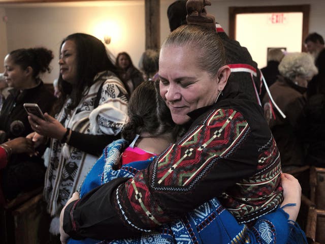 Jessie "Little Doe" Baird, front right, vice chairwoman of the Mashpee Wampanoag tribe, hugs a member of the audience following the "We Gather Together" celebration at the Old Indian Meeting House in Mashpee, Massachusetts