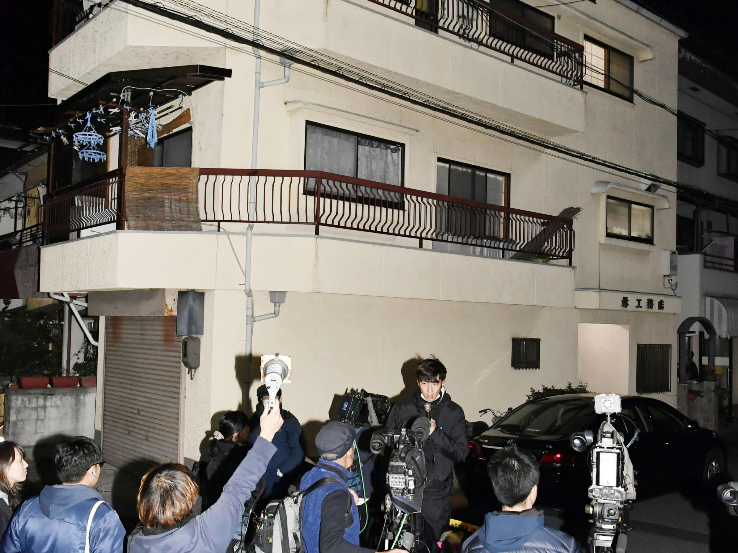 Press gather outside the apartment in Neyagawa, Osaka, where buckets filled with concrete and human bones were found