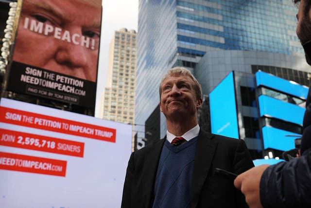 Tom Steyer stands in front of one of the billboards he has funded in Times Square calling for the impeachment of President Donald Trump