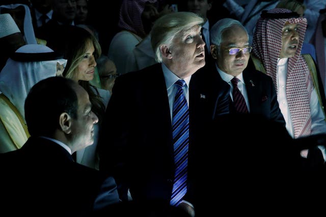 U.S. President Donald Trump (C) and other leaders react to a wall of computer screens coming online as they tour the Global Center for Combatting Extremist Ideology in Riyadh, Saudi Arabia