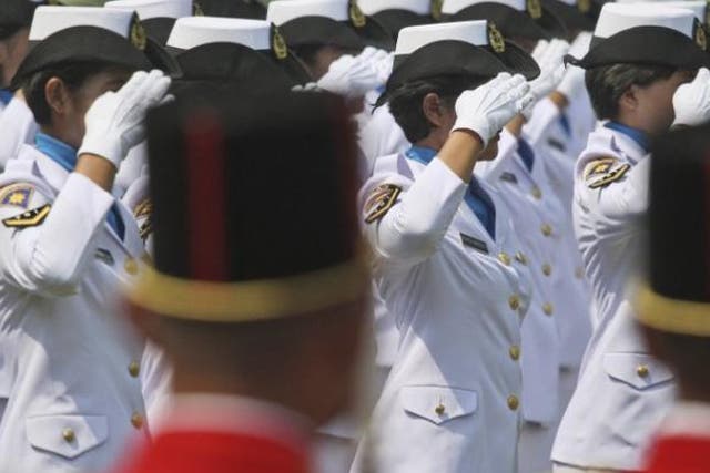 Indonesian police officers salute on parade