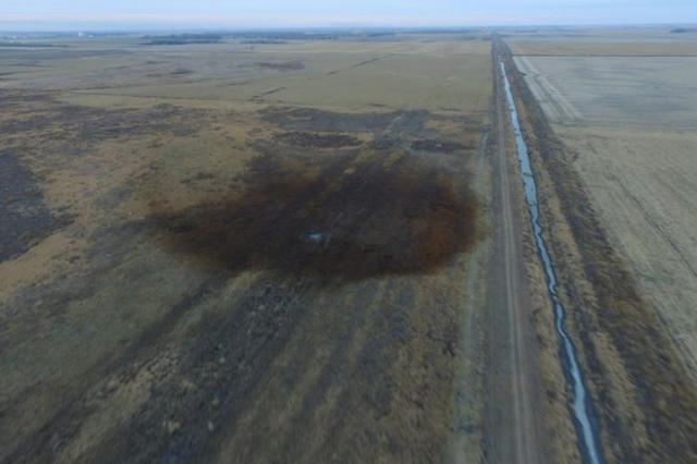 An aerial view shows the darkened ground of an oil spill which shut down the Keystone pipeline between Canada and the United States, located in an agricultural area near Amherst, South Dakota. REUTERS/Dronebase