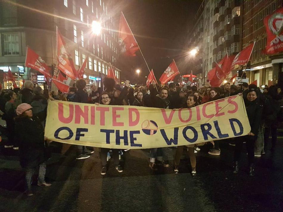 Protestors hold up a banner during a protest held in solidarity with a University of London cleaners' strike