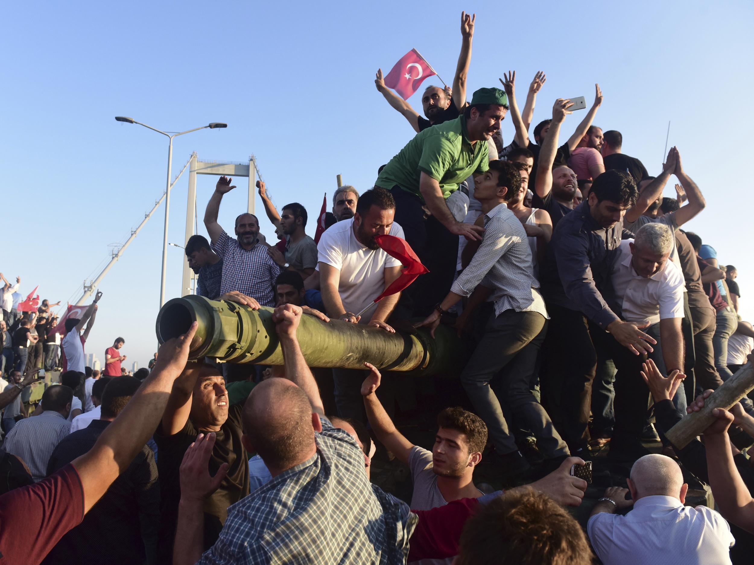Supporters of Turkish President Recep Tayyip Erdogan celebrate after soldiers involved in the coup surrendered on the Bosphorus Bridge in Istanbul on 16 July 2016